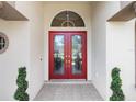 Elegant red double front doors with etched glass at 5378 Legend Hills Ln, Spring Hill, FL 34609