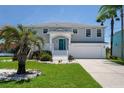 Two-story house with gray siding, white trim, and a teal front door at 3480 Croaker Dr, Hernando Beach, FL 34607