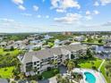 Aerial view of condo building near waterway, showcasing pool and landscape at 5537 Sea Forest Dr # 307, New Port Richey, FL 34652