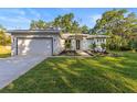 Charming home with manicured lawn, featuring an attached garage and meticulously landscaped front yard at 9229 Creston Ave, New Port Richey, FL 34654