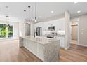 Open kitchen featuring granite countertops, stainless appliances, and a large center island at 9229 Creston Ave, New Port Richey, FL 34654
