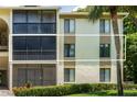 Exterior view of a condo building showcasing a balcony and surrounding landscaping at 3232 Lake Pine E Way # H2, Tarpon Springs, FL 34688