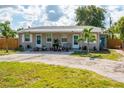 Front view of a charming gray duplex with lush landscaping and a paved driveway at 6805 Gulf Winds Dr, St Pete Beach, FL 33706