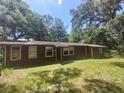 Ranch-style home with brown exterior and a grassy yard at 21343 Beasley St, Brooksville, FL 34601