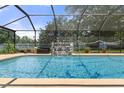 Inviting screened pool with a waterfall feature at 6096 Kinlock Ave, Spring Hill, FL 34608
