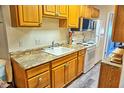 Efficient kitchen with wood cabinets and granite counters at 1955 Abrico Dr # G7, Lutz, FL 33558