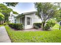 White house with green lawn and landscaping at 2727 Featherstone Dr # 2727, Holiday, FL 34691