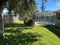 Private backyard oasis with a screened-in pool and spacious lawn at 402 Knight Dr, Tarpon Springs, FL 34688