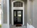 Elegant front door with glass accents and arched window at 402 Knight Dr, Tarpon Springs, FL 34688