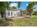 Home's backyard with patio, stonework, and tropical landscaping at 9 Grace St, Crystal Beach, FL 34681