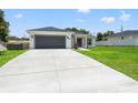 One-story house with a gray garage door and a large concrete driveway at 5328 Baldock Ave, Spring Hill, FL 34608