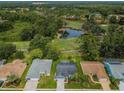 Aerial view of a community with houses, golf course, and pond at 9727 Oakwood Hills Ct, New Port Richey, FL 34655