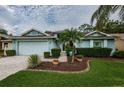 Single-Gathering home with light blue exterior and landscaping at 9727 Oakwood Hills Ct, New Port Richey, FL 34655