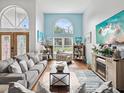 Bright living room with hardwood floors, comfy seating, and a fireplace at 1096 Florian Way, Spring Hill, FL 34609