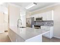 Modern kitchen with white cabinets, quartz countertops, and stainless steel appliances at 5614 Red Snapper Ct, New Port Richey, FL 34652