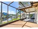 Spacious screened porch overlooking the waterfront with a wooden deck at 6316 Spoonbill Dr, New Port Richey, FL 34652