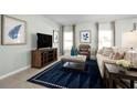 Bright living room featuring a cozy sitting area and large TV at 14300 Whitewater Way, Brooksville, FL 34604