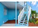 Bright blue home exterior with white staircase leading to upper level at 13521 Stacey Dr, Hudson, FL 34667