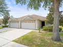 Tan house with a two car garage at 3897 Crossline Dr, Spring Hill, FL 34609