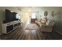 Living room with hardwood floors, sectional sofa, and large TV at 4201 Avanti Cir, New Port Richey, FL 34655