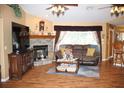 Living room with a fireplace, hardwood floors, and comfortable seating at 17852 Fancy Ln, Hudson, FL 34667