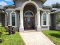 Elegant front entrance with arched entryway and columns at 11033 Baywind Ct, Weeki Wachee, FL 34613
