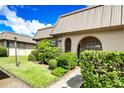 Tan condo with arched entryway and lush landscaping at 4129 Stratford Dr # 4129, New Port Richey, FL 34652