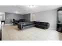 Living room with leather sectional sofa and dark tile flooring at 7446 Donegal St, New Port Richey, FL 34653