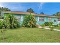 Light teal home with a well-manicured lawn and tropical landscaping at 800 61St N St, St Petersburg, FL 33710