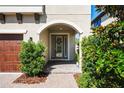 Close up of the front door with sidelights, archway, brick walkway, and manicured landscaping at 3893 Burdick Loop, Odessa, FL 33556