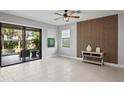 Spacious living room with sliding glass doors to the patio, a feature wall, tile floors and a ceiling fan at 3893 Burdick Loop, Odessa, FL 33556
