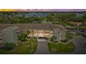 Waterfront condo complex at sunset with manicured landscaping, convenient parking, and water views at 8210 Aquila St # 227, Port Richey, FL 34668
