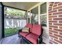 Comfortable patio seating area with a red cushioned loveseat and a decorative 'stay awhile' pillow, perfect for relaxing outdoors at 6635 Stewart N Ave, St Petersburg, FL 33702