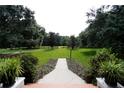 Landscaped front yard with walkway leading to home at 23337 Lake Lindsey Rd, Brooksville, FL 34601