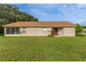 Tan house with brown roof, screened porch, and burgundy door at 11158 Heathrow Ave, Spring Hill, FL 34609