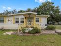 Front view of a yellow house with wooden steps and deck at 9140 & 9130 Peony St, New Port Richey, FL 34654