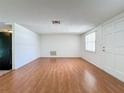 Bright living room with wood floors and white walls offering versatile space and a front door entrance at 7206 Ashwood Dr, Port Richey, FL 34668