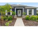 Front entrance with walkway, landscaping, and navy blue siding at 5406 Boxtree Ct, Dade City, FL 33523