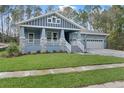 Inviting craftsman style home featuring a cozy front porch with stone accents and a well-maintained lawn at 3898 Southern Valley Loop, Brooksville, FL 34601