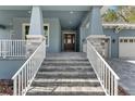 Inviting front entrance with a beautiful stone stairway, a decorative front door and a covered porch at 3898 Southern Valley Loop, Brooksville, FL 34601