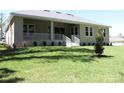 Expansive backyard featuring well-maintained lawn, covered patio and lush landscaping at 4676 Hickory Oak Dr, Brooksville, FL 34601