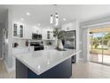 Bright kitchen features white cabinets, stainless appliances, and large island with patio access at 7332 Mako Dr, Hudson, FL 34667