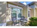 Small patio with wrought iron furniture and lush green landscaping at 3605 Kings Rd # 102, Palm Harbor, FL 34685