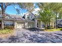 Tan two-story townhome with a two-car garage and well-manicured landscaping at 3605 Kings Rd # 102, Palm Harbor, FL 34685