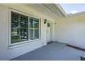 Inviting front entry featuring a textured wall finish and a modern exterior light fixture at 8521 Cedarview Ct, Port Richey, FL 34668