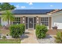 Home exterior featuring solar panels and attractive landscaping at 3077 Ardenwood Dr, Spring Hill, FL 34609