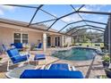 Relaxing pool area with a covered patio and blue lounge chairs at 13931 Chandron Dr, Odessa, FL 33556