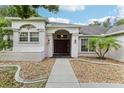 Home's entrance with walkway, landscaping and double doors at 8088 Spanish Oak Dr, Spring Hill, FL 34606