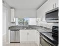 Modern kitchen with white cabinets, granite countertops, and stainless steel appliances at 2424 W Tampa Bay Blvd # L-302, Tampa, FL 33607