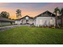 Charming one-story home featuring a well-manicured lawn and a long, paved driveway at 19395 Sheltered Hill Dr, Brooksville, FL 34601